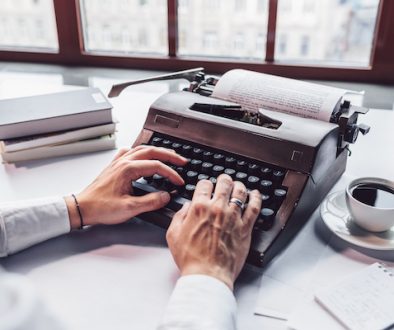 Young writer typing on a retro typewriter