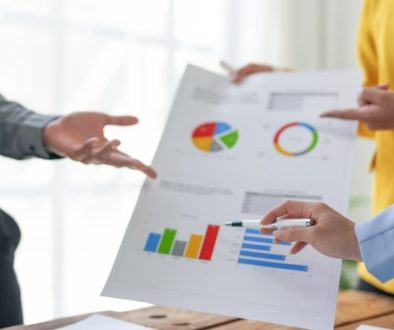 Business meeting with professionals discussing financial data and analysis reports in a modern office setting.