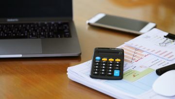 computer-on-table-with-smartphone-documents-and-c-2024-12-07-12-44-41-utc
