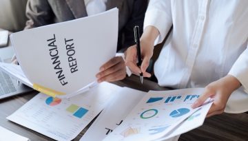 Closeup hand of Chief and employee discuss monthly earning graph together in the office